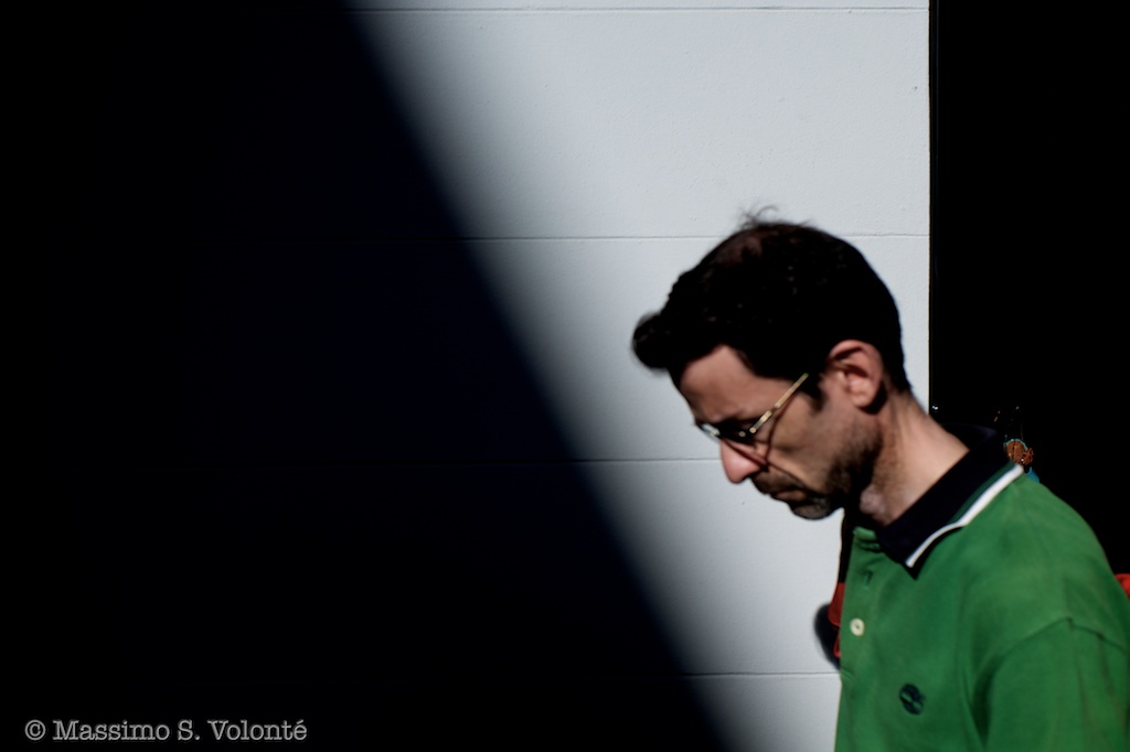 Man walking with sharp shadow and light background